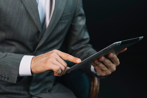 Close-up of a businessman's hand touching the digital tablet screen