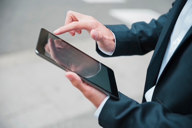 Free photo close-up of businessman's hand using digital tablet