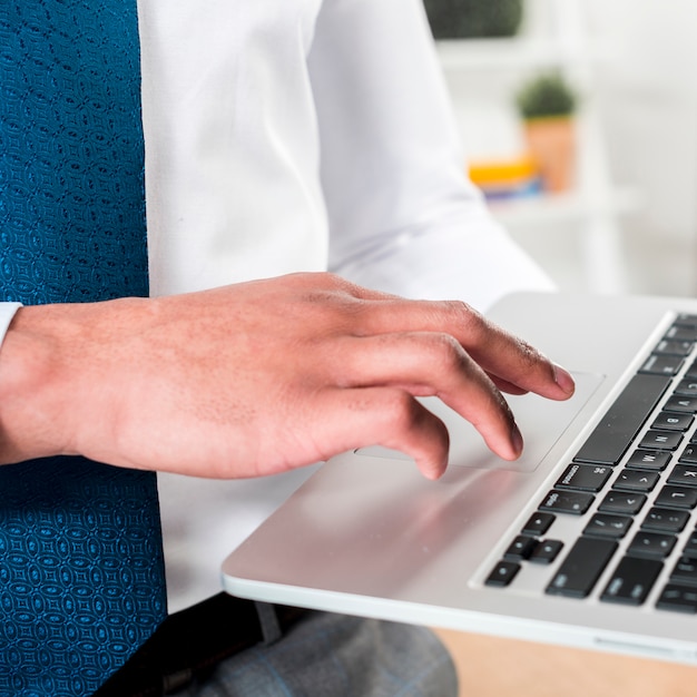 Close-up of a businessman's hand using laptop