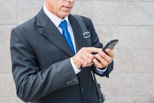 Close-up of a businessman's hand using mobile phone