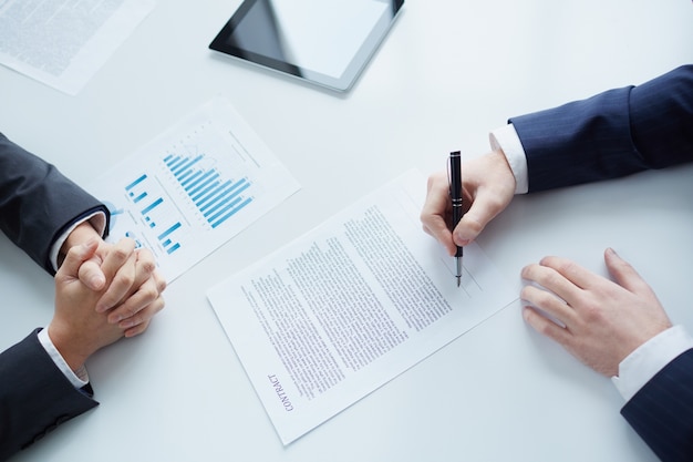 Free Photo close-up of businessman sitting and signing a contract