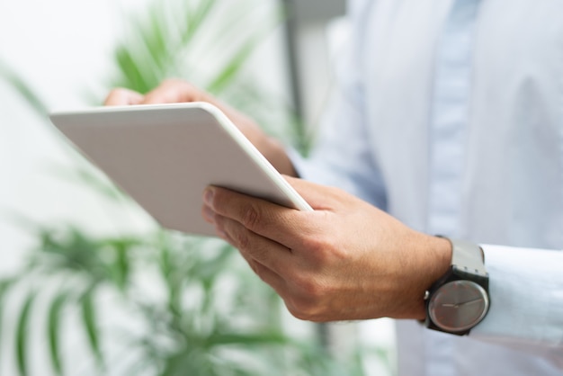 Free Photo close-up of businessman with wristwatch using tablet