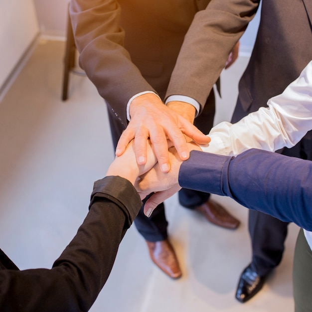 Free Photo close-up of businesspeople stacking hands in meeting at office