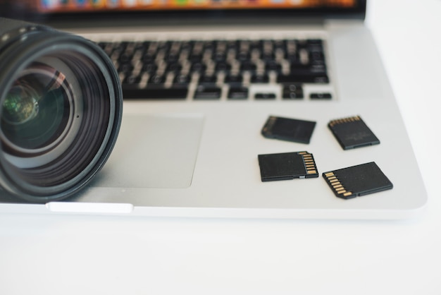 Free photo close-up of camera lens and memory cards on laptop