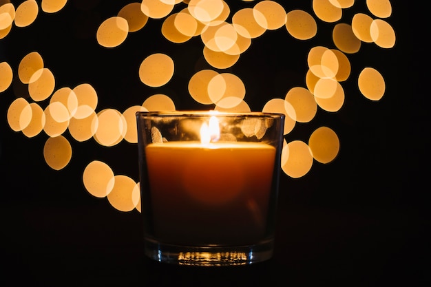 Free Photo close-up candle near blurred lights