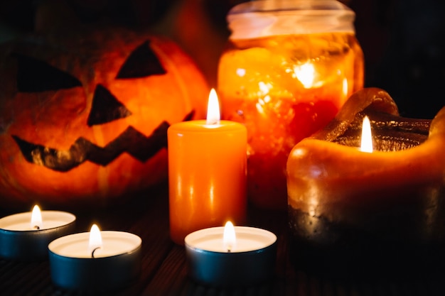 Free photo close-up of candles and halloween pumpkin