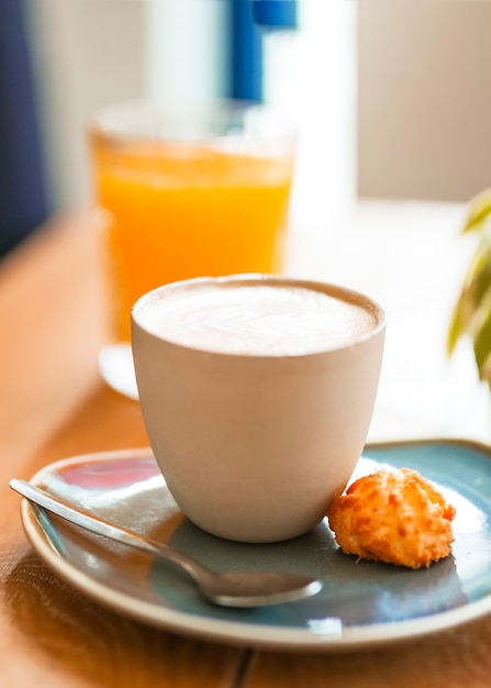 Free photo close-up of cappuccino coffee with cookie and spoon