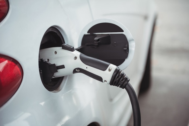 Close-up of car being charged with electric car charger