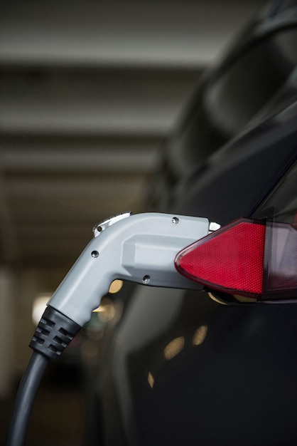 Close-up of car being charged with electric car charger