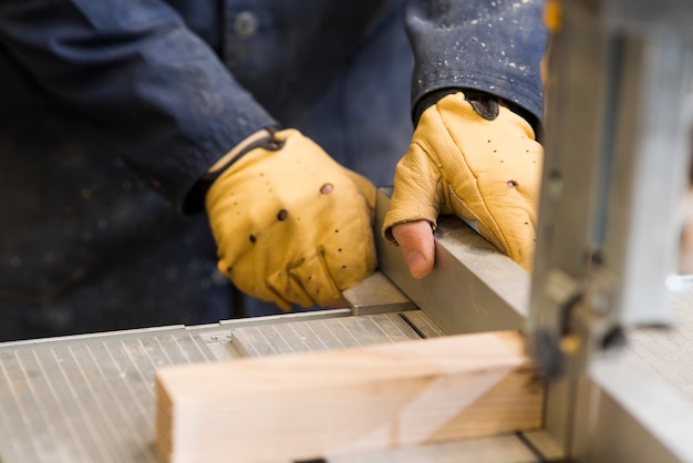 Close-up of a carpenter hands working with wooden block on workbench