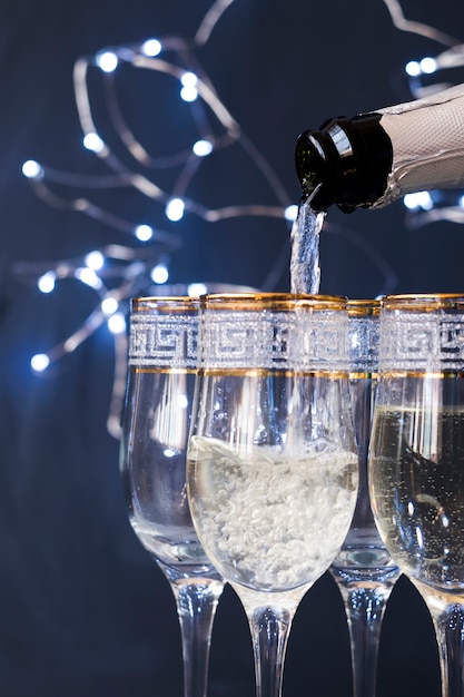 Free photo close-up of champagne pouring into the glass at night