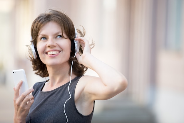 Close-up of cheerful woman listening to music