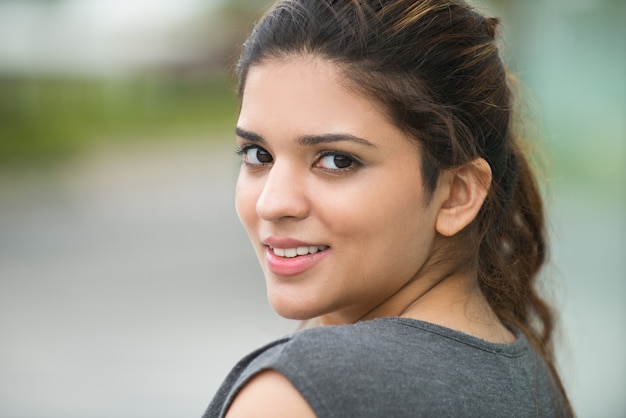 Close-up of cheerful young woman looking at camera