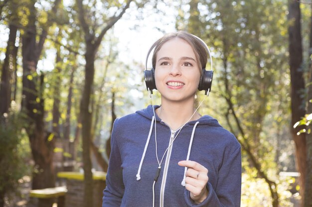 Free Photo close-up of cheerful young woman running outdoors