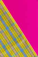 Free photo close-up of chequered pattern textile on pink background