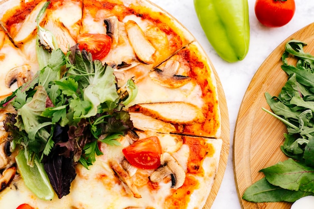 Close up of chicken pizza with mushroom tomato topped with herbs