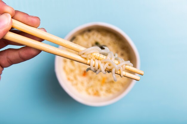 Close-up chopsticks with noodles