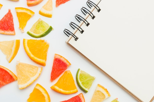 Close-up of citrus fruit slices with spiral notepad