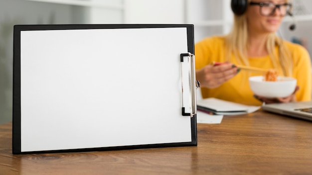 Close-up clipboard on the desk with woman behind