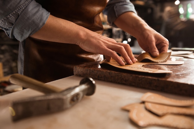 Close up of a cobbler working with leather