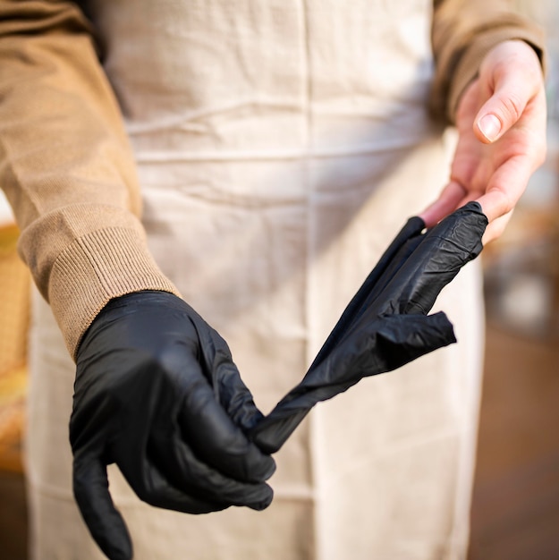 Close-up coffee shop worker taking gloves off