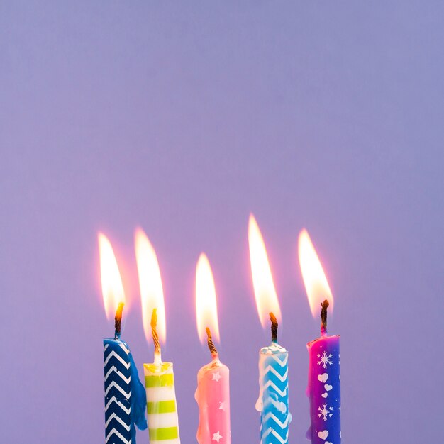 Close-up colorful candles on purple background