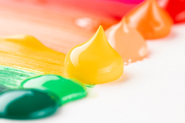 Free photo close-up of colorful paint on white table