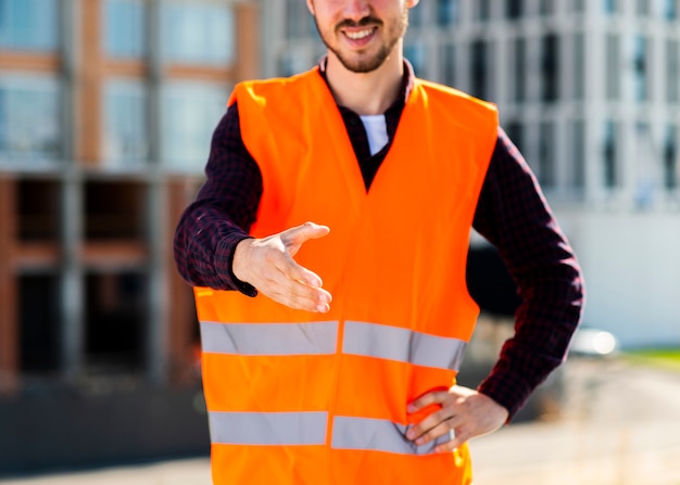 Free Photo close-up construction worker offering handshake