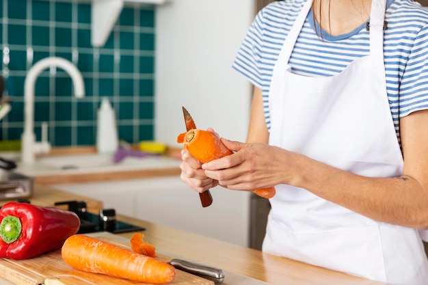 Close up cook peeling carrot