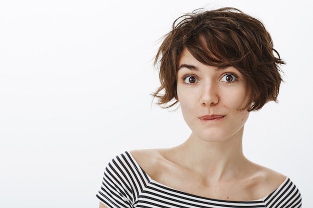 Close-up of coquettish cute woman looking intrigued