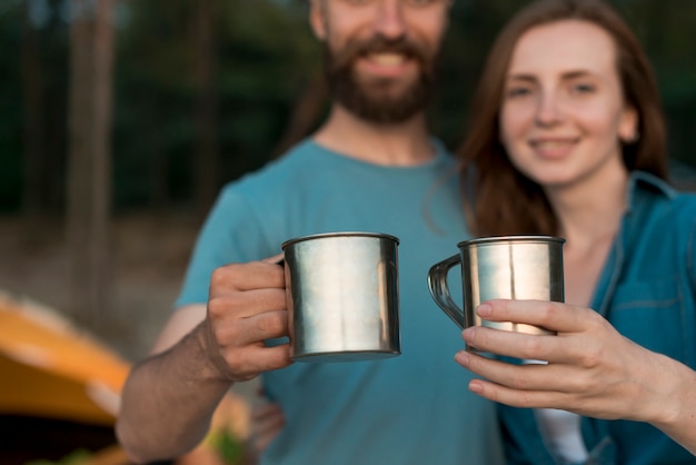 Close up couple holding drinking cups