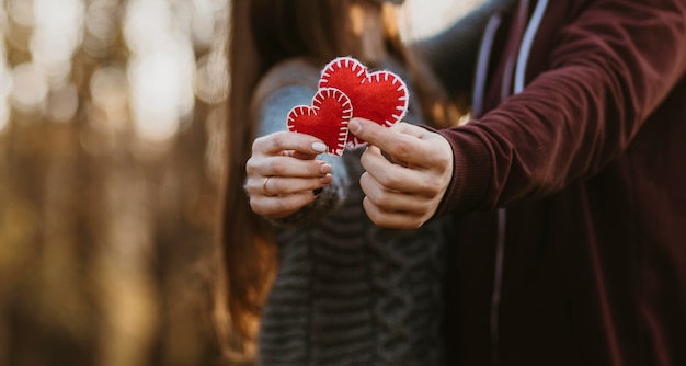 Free photo close-up couple holding little hearts