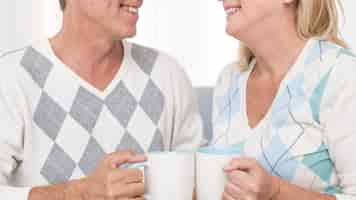 Free photo close-up couple holding white mugs