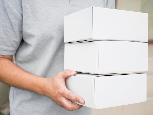 Free photo close-up courier holding white boxes