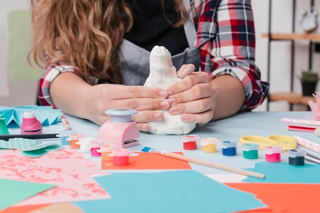 Free photo close-up of craftswoman kneading white clay on table