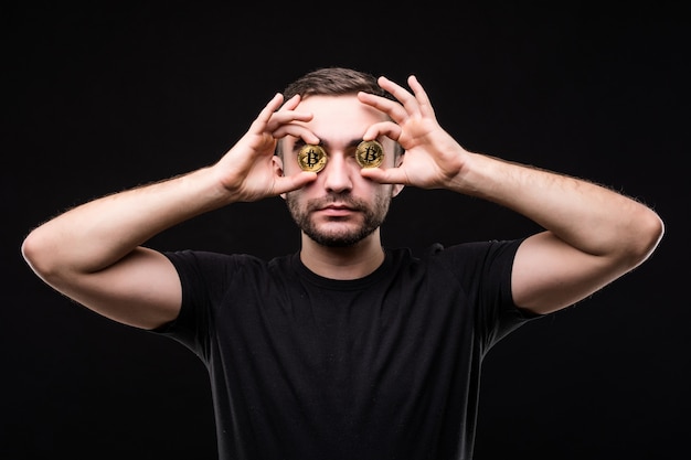 Free photo close up of a crazy entrepreneur with bitcoins in his eyes pointing fingers isolated over black