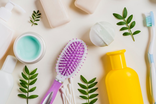 Close-up of cream; hairbrush; soap; bath bomb; toothbrush on white backdrop