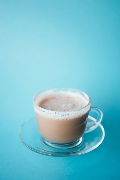 Close-up cup of coffee latte with blue background