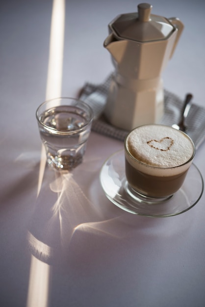 Close-up cup of coffee latte with kettle