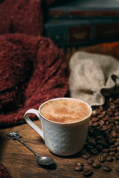 Close-up cup of coffee with roasted beans