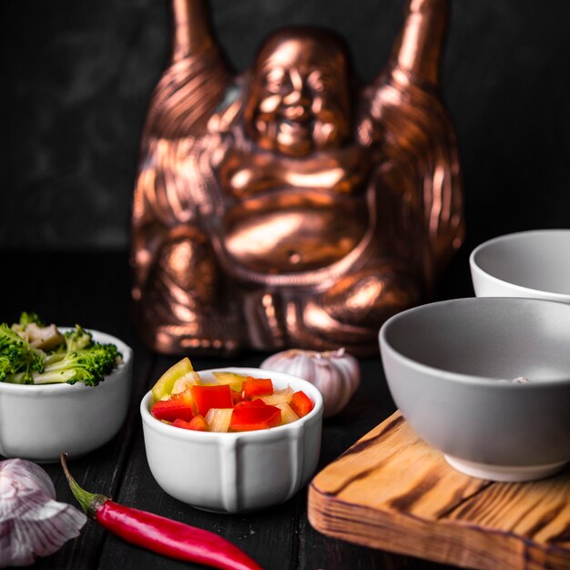 Close-up of cups of vegetables with statue