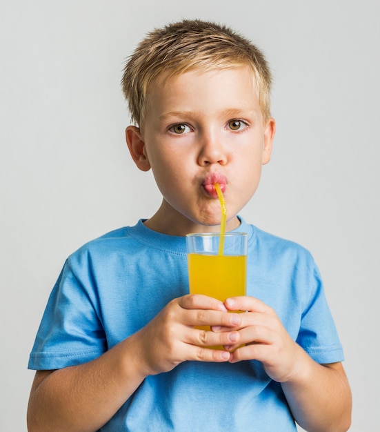 Close-up cute child drinking juice