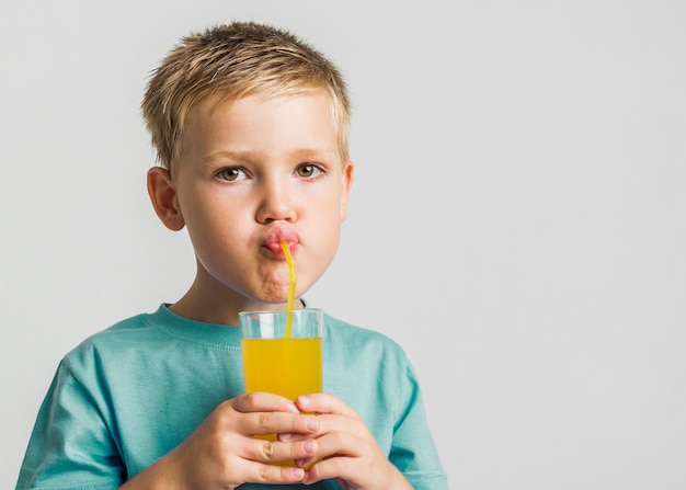 Free photo close-up cute kid drinking juice