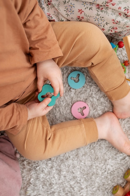 Free Photo close up cute kid holding wooden toy