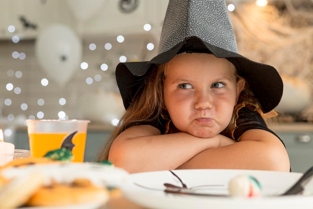 Close-up of cute little girl with witch costume