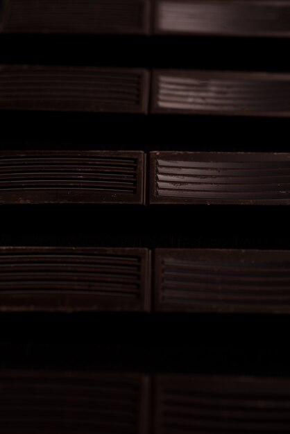 Close-up of dark chocolate bar tiles in a line