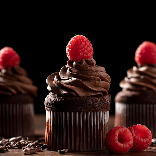 Free photo close-up of delicious chocolate cupcakes with raspberry