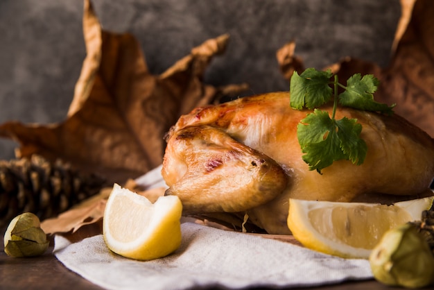 Free photo close-up of a delicious roasted chicken with lemon slice on table cloth