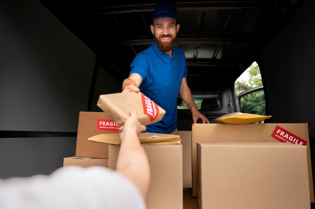 Close up delivery man holding box