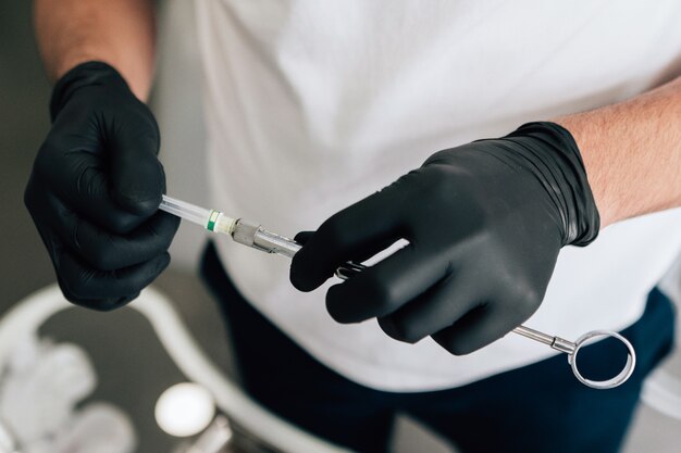 Close-up of dentist holding equipment with surgical gloves